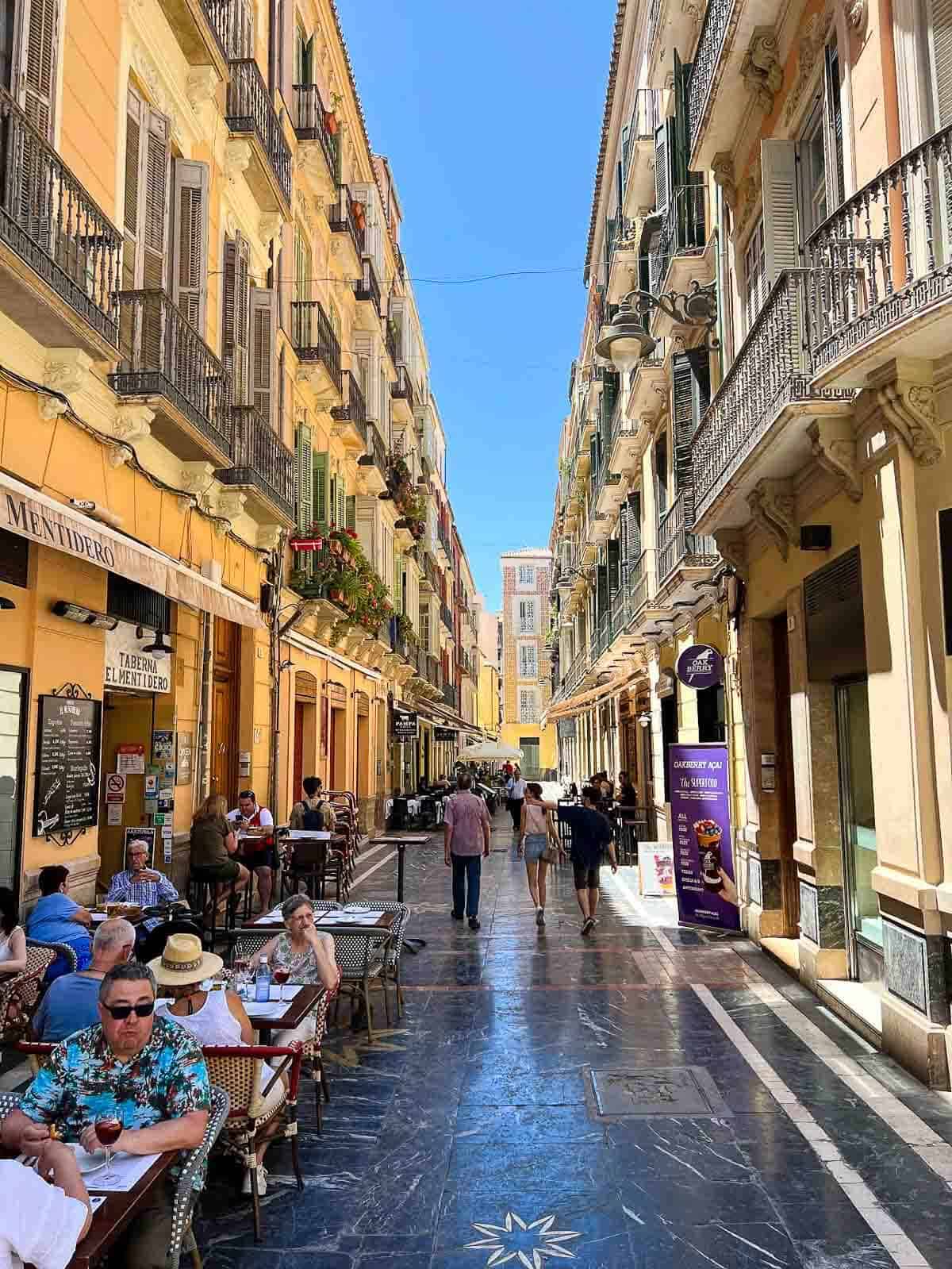 Centro Histórico de Málaga de noche: Calles empedradas iluminadas con luces cálidas, resaltando la arquitectura tradicional.