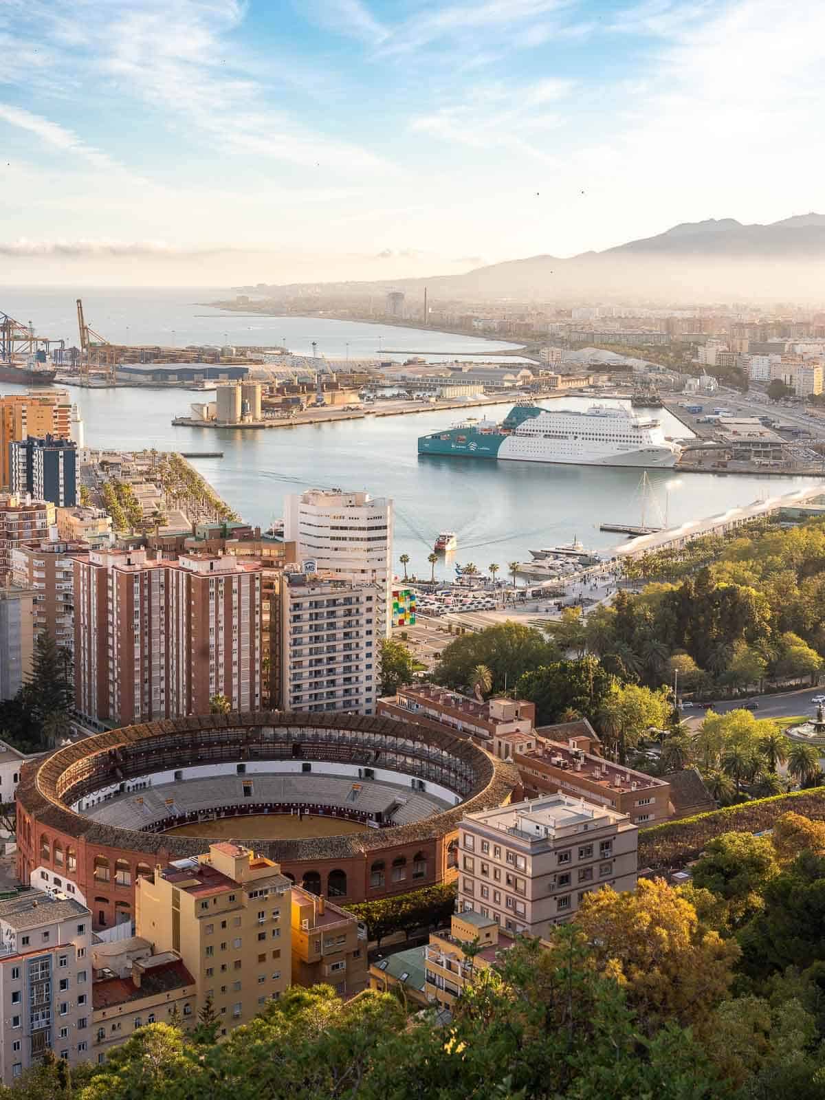 Playa y centro histórico de Málaga: Vista panorámica del puerto de Málaga con la plaza de toros y la catedral al amanecer.