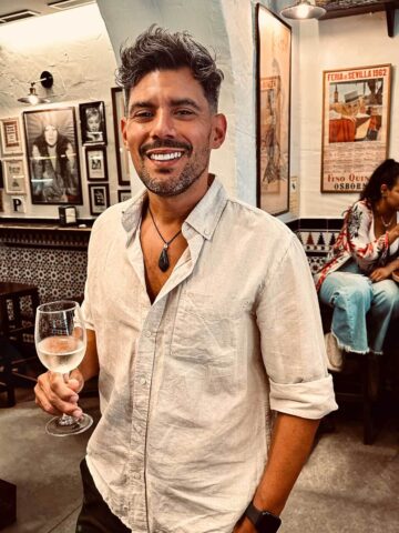 hombre tomando una copa de vino blanco en el icónico bar La Tranca.