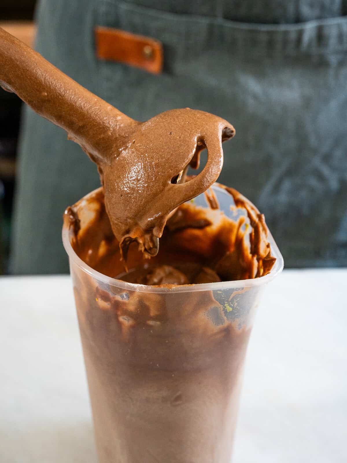 Mousse de chocolate vegano con aguacate recién batido, mostrando su textura cremosa en una batidora de mano.