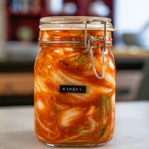 receta de Kimchi vegano fermentado en tarro de vidrio, receta coreana con col china, gochugaru y especias naturales.