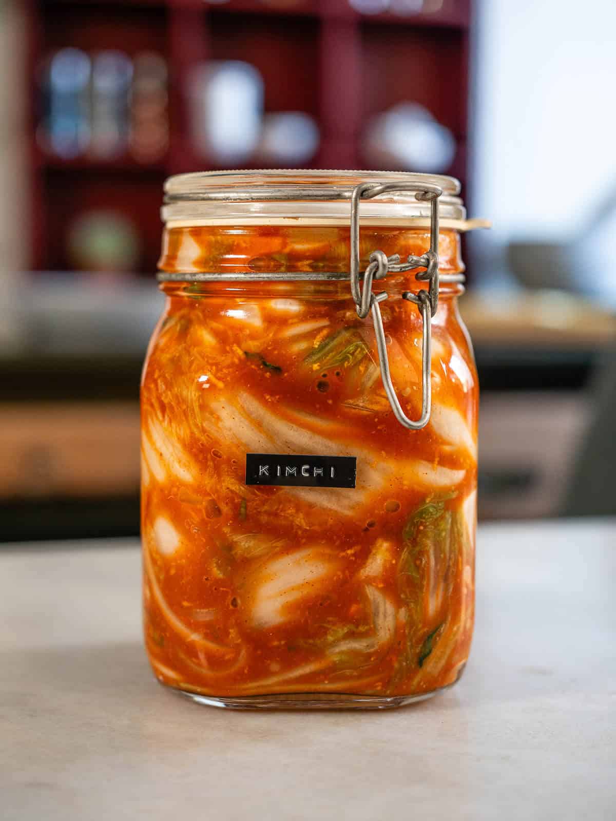 receta de Kimchi vegano fermentado en tarro de vidrio, receta coreana con col china, gochugaru y especias naturales.