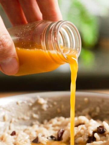 vertiendo el jugo de mandarina sobre el arroz cocinado.