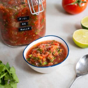 Primer plano del pico de gallo en un bol blanco, mostrando su textura fresca y colorida.