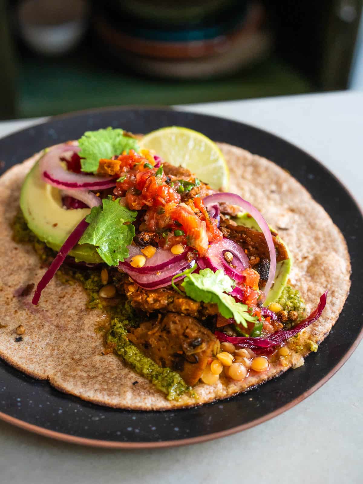 Taco vegano con seitán, aguacate, cebolla encurtida y pico de gallo fresco como topping.