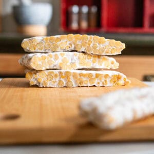 Bloques de tempeh vegano casero listos para cortar, con superficie blanca característica del fermento.