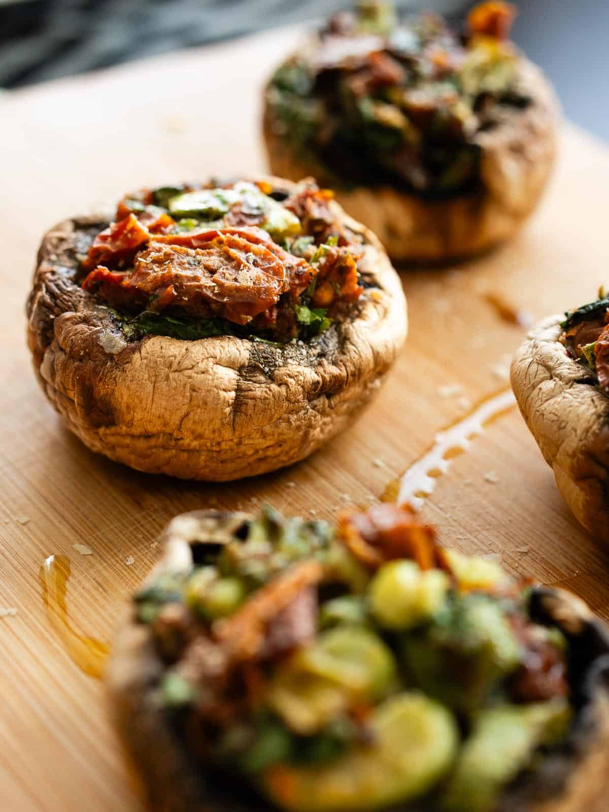 Champiñón portobello relleno vegano al horno, enfoque lateral, relleno colorido de verduras y queso vegano.