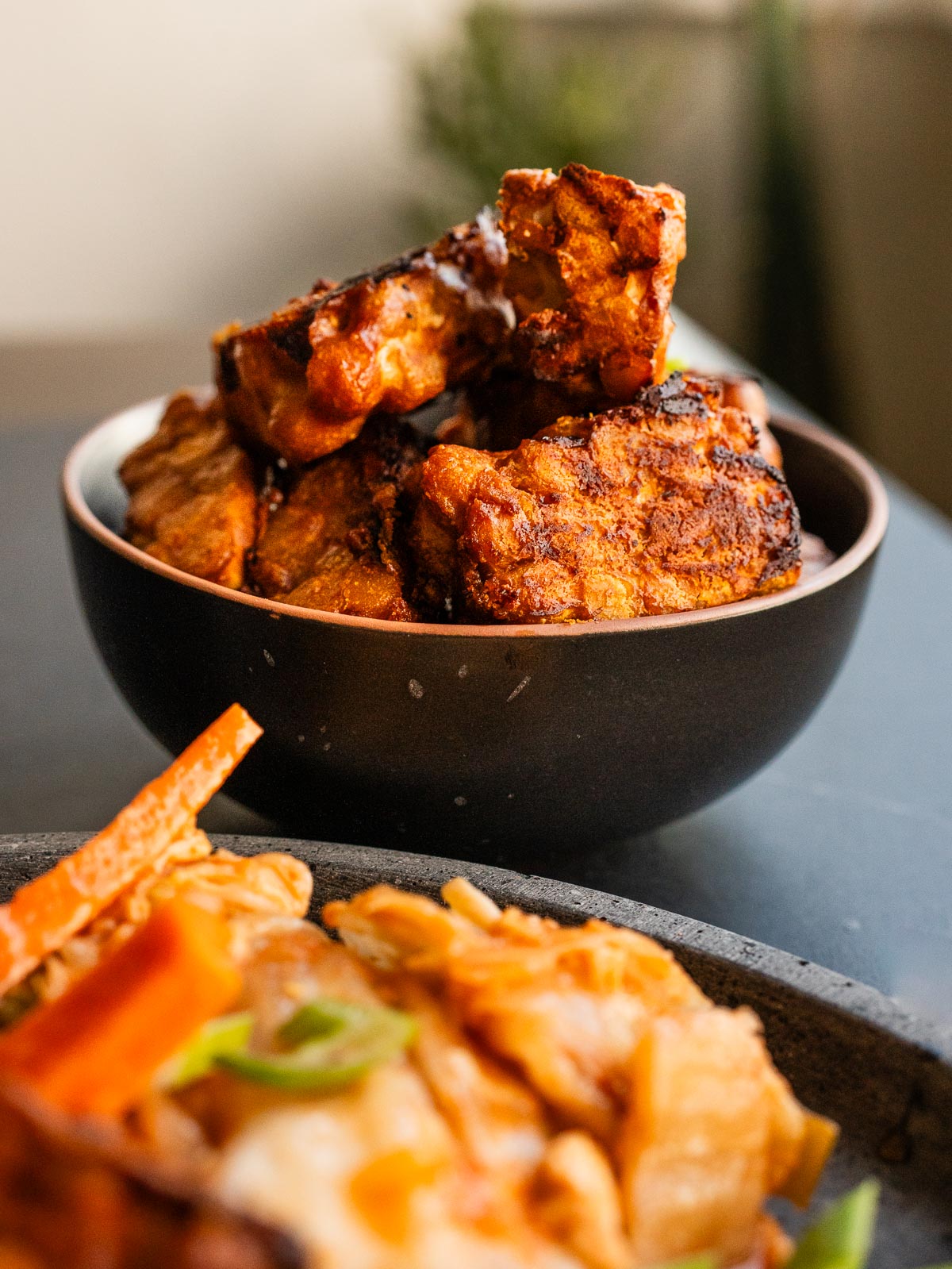Tempeh dorado servido en un bol pequeño como acompañamiento.