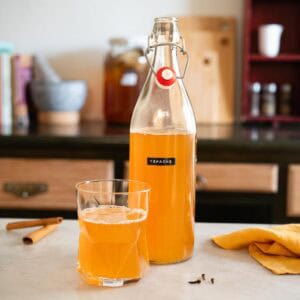 Botella de tepache casero lista para servir como bebida fermentada refrescante.