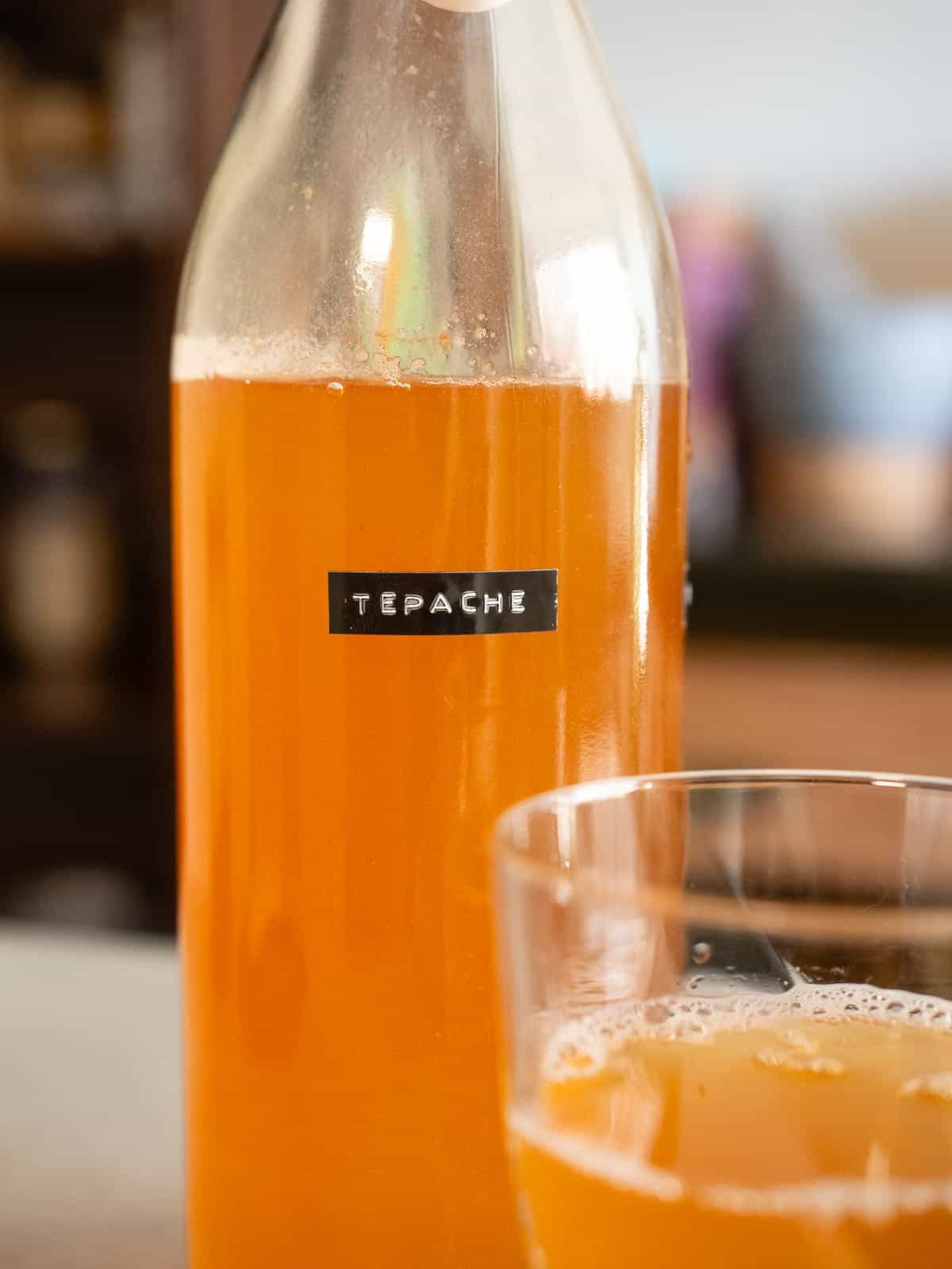 Detalle de botella con tepache casero fermentado de piña artesanal.